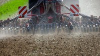 Sebuah traktor dengan unit penyemaian berjalan di atas ladang kering di Kemlitz, Jerman, Rabu (24/8/2022).