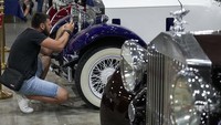 Seorang pengunjung memperhatikan detail dari mobil klasik yang dipamerkan.