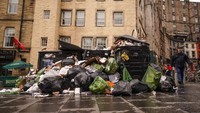 Tumpukan besar kantong sampah terlihat di sebelah tempat sampah yang meluap di Grass Market, Edinburgh.