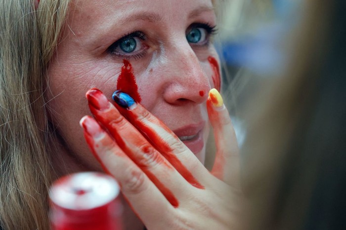 A woman made up with the outline of a map of Ukraine on her face takes part in a so called Freedom March demonstration, marking the Ukrainian Independence Day in Berlin, Germany, Wednesday, Aug. 24, 2022. European leaders are pledging unwavering support for Ukraine as the war-torn country marks its Independence Day. The commemorations Wednesday coincide with the six-month milestone of Russia's invasion. (AP Photo/Markus Schreiber)
