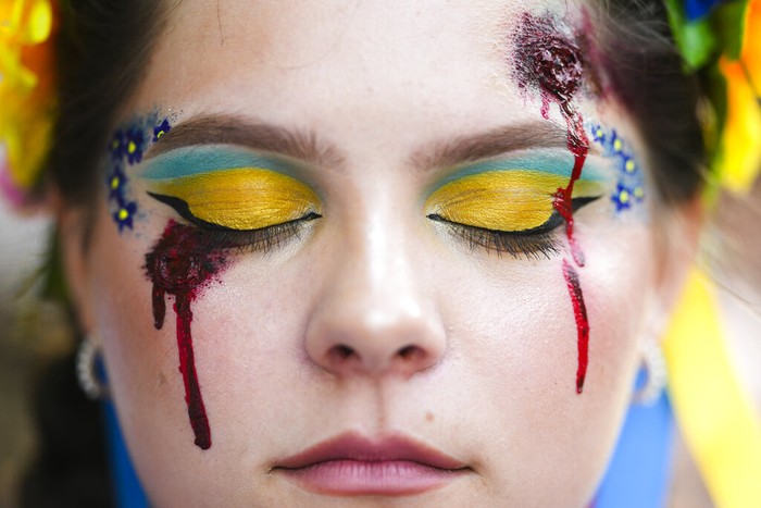 A woman made up with the outline of a map of Ukraine on her face takes part in a so called Freedom March demonstration, marking the Ukrainian Independence Day in Berlin, Germany, Wednesday, Aug. 24, 2022. European leaders are pledging unwavering support for Ukraine as the war-torn country marks its Independence Day. The commemorations Wednesday coincide with the six-month milestone of Russia's invasion. (AP Photo/Markus Schreiber)