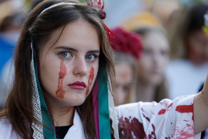 A woman made up with the outline of a map of Ukraine on her face takes part in a so called Freedom March demonstration, marking the Ukrainian Independence Day in Berlin, Germany, Wednesday, Aug. 24, 2022. European leaders are pledging unwavering support for Ukraine as the war-torn country marks its Independence Day. The commemorations Wednesday coincide with the six-month milestone of Russia's invasion. (AP Photo/Markus Schreiber)