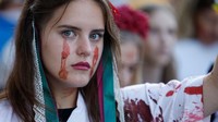 Perempuan ini melukis wajahnya seolah-olah sedang menangis darah. 24 Agustus diperingati Ukraina sebagai kemerdekaan dari Uni Soviet tahun 1991. Saat ini, Rusia sedang menginvasi negeri itu dengan operasi militer besar-besaran.  (Odd Andersen/AFP via Getty Images)