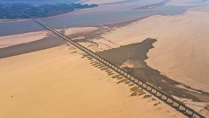 JIUJIANG, CHINA - AUGUST 24, 2022 - Aerial photo taken on Aug 24, 2022 shows the dry water area near Poyang Lake Bridge in Jiujiang City, East China's Jiangxi Province. Since July, the water level of Poyang Lake, the largest freshwater lake in China, has continued to drop due to high temperature and little rainfall, breaking the record of entering dry season and low dry season for the first time since 1951. As of 0:00 on August 25, the water level of Xingzi station in Poyang Lake was 9.53 meters. (Photo credit should read CFOTO/Future Publishing via Getty Images)