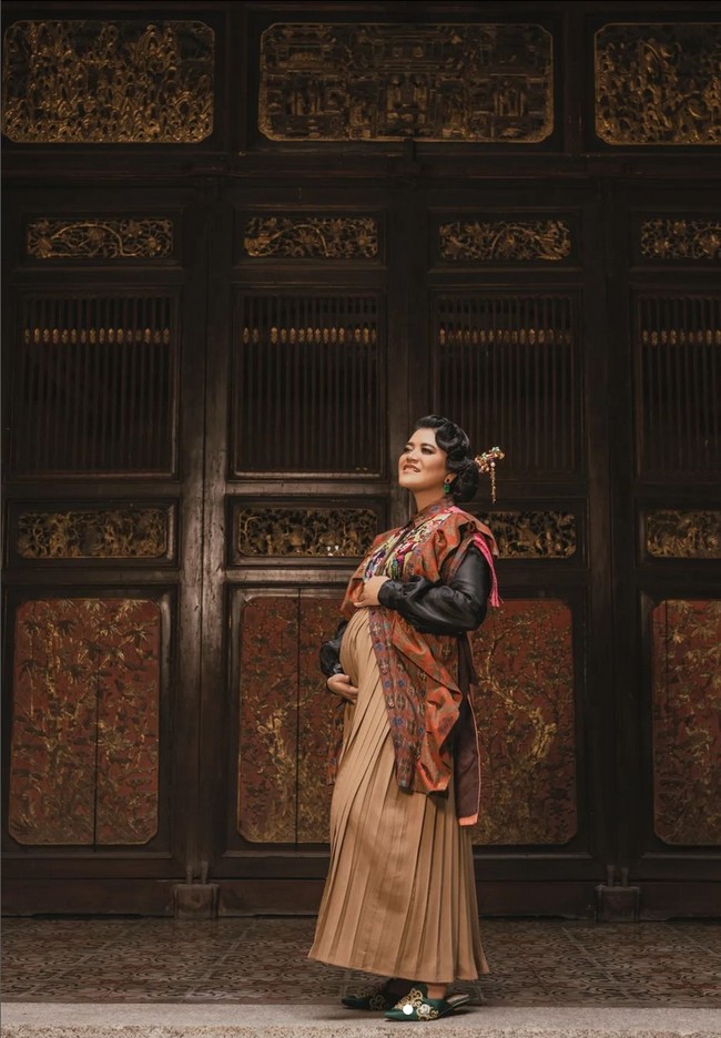 Pemotretan kehamilan digarap oleh fotografer Rio Motret dengan konsep nuansa etnik dan vintage. Kahiyang Ayu tampak mengenakan rok panjang aksen lipit yang dipadu blouse dan rompi ruffle rancangan desainer Mel Ahyar. Foto: Instagram
