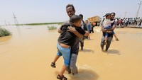 Warga mengevakuasi anak-anak korban banjir di Kota Gezira, Sudan, 23 Agustus 2022.