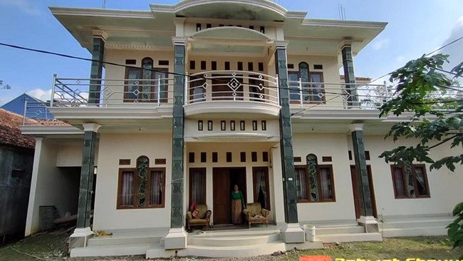 Tampak depan, rumah TKI Arab Saudi itu terlihat megah dengan cat warna cream dan empat beton pilar yang terbuat dari batu hias jenis andesit hitam.  Foto: Dok. Youtube Rahmat Channel.