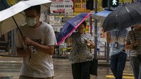 Warga bergegas melintasi jalanan di tengah angin kencang yang melanda kota itu. Hong Kong telah mengeluarkan peringatan topan tertinggi ketiga pada Rabu malam ketika badai itu bergerak lebih dekat ke kota.