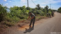 Prajurit Lanal Tarempa membersihkan jalan raya di Desa Temburun. Kegiatan ini berkaitan dengan program unggulan TNI AL yaitu Kampung Bahari Nusantara.   