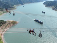 YICHANG, CHINA - AUGUST 25, 2022 - Aerial photo taken on Aug 25, 2022 shows workers installing spacers across the Yangtze River on the ultra-high voltage 