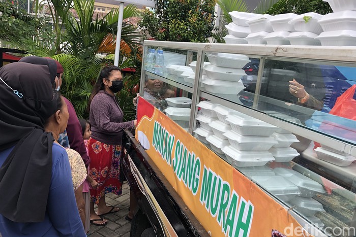 Warga mengantre untuk membeli nasi kotak murah di halaman Kantor Kelurahan Pondok Betung, TAngerang Selatan. Paket nasi murah itu khusus dijual pada hari Jumat pagi.