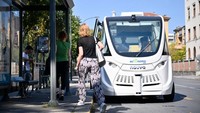 Para penumpang menaiki bus tanpa pengemudi di sebuah halte di Turin, Italia, Kamis (25/8/2022).