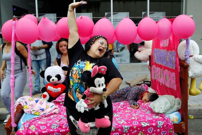 A woman simulates to be asleep during the World Day of Laziness in Itagui, Colombia, on August 21, 2022. (Photo by Fredy Builes / AFP) (Photo by FREDY BUILES/AFP via Getty Images)