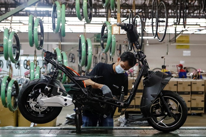 An employee works at the assembly line of an electric motorcycle at the United E-Motor factory in Bogor, near Jakarta, Indonesia, August 25, 2022. REUTERS/Ajeng Dinar Ulfiana