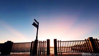 Siluet dari pagar pembatas dan lampu dermaga jadi spot foto yang instagrammable. (Bonauli/detikcom)