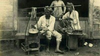 Ini potret penjual makanan keliling yang sedang melayani pembeli. Foto ini diambil di Jawa sekitar tahun 1930. Foto: Instagram @potret.sejarahindonesia