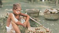 Anak-anak kala itu pun banyak yang membantu orangtua dengan berjualan makanan keliling. Seperti bocah penjual buah-buahan menggunakan pikulan ini. Foto ini diambil di Batavia tahun 1906. Foto: Instagram @potret.sejarahindonesia/KITLV Leiden 