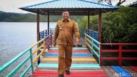 Bupati Kepulauan Anambas, Abdul Haris, berjalan di kawasan wisata Batu Belangkop di Desa Batu Belah, Kabupaten Kepulauan Anambas, Kepulauan Riau, Senin (1/8/2022). Desa ini diresmikan sebagai Kampung Bahari Nusantara oleh Lanal Tarempa beserta Bupati Kabupaten Kepulauan Anambas pada tahun 2021.   