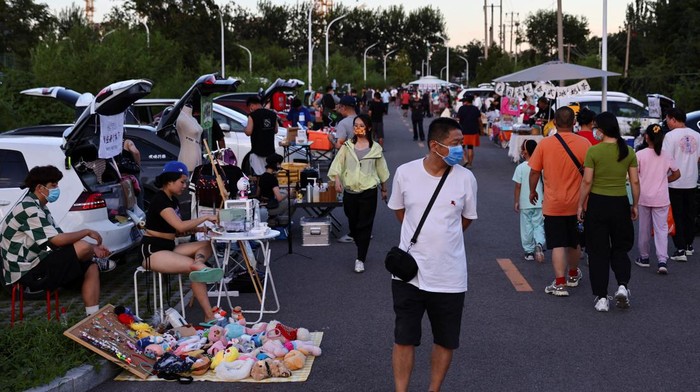 People walk at a car boot fair in Beijing, China August 19, 2022. REUTERS/Tingshu Wang