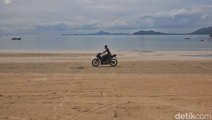 Pengendara motor melintas di Pantai Padang Melang, Letung, Pulau Jemaja, Kabupaten Kepulauan Anambas, Kepulauan Riau, Sabtu (6/8/2022).