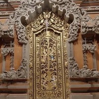 Pintu masuk tetap konsisten dengan ukiran Bali yang memukau. Warna emas memberi sentuhan mewah. (Foto: YouTube/Tiara Andini)