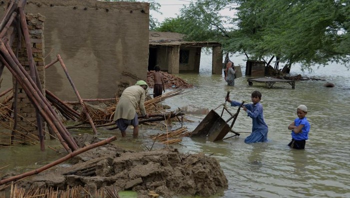 A family salvage usable items from their flood-hit home in Jaffarabad, a district of Pakistans southwestern Baluchistan province, Thursday, Aug. 25, 2022. Pakistans government in an overnight appeal sought relief assistance from the international community for flood-affected people in this impoverished Islamic nation, as the exceptionally heavier monsoon rain in recent decades continued lashing various parts of the country. (AP Photo/Zahid Hussain)