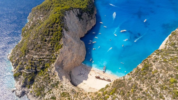 ZAKINTHOS, GREECE - AUGUST 09: Aerial view of Navagio Beach or Shipwreck Beach on August 09, 2022 in Zakinthos, Greece. On 2 October 1980, the ship ran aground in the waters during stormy weather and bad visibility. Some rumours claim the ship was smuggling contraband from Turkey with a freight of contraband cigarettes headed for Italy. The ship was abandoned and still rests buried in the limestone gravel of the beach named Shipwreck. In 2018, the beach was named as the world's best beach in a poll by journalists. (Photo by Athanasios Gioumpasis/Getty Images)