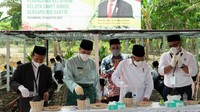 Wapres Maruf Amin, Gubernur Provinsi Riau Syamsuar dan pejabat lain melakukan penanaman bibit kelapa sawit. Terlihat juga di belakang, para santri ikut menanam bibit tersebut.