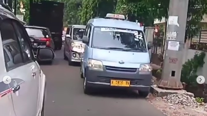 Angkot parkir di bahu Jl Cipinang Muara, Jaktim dan ditinggal sopir makan hingga bikin macet.