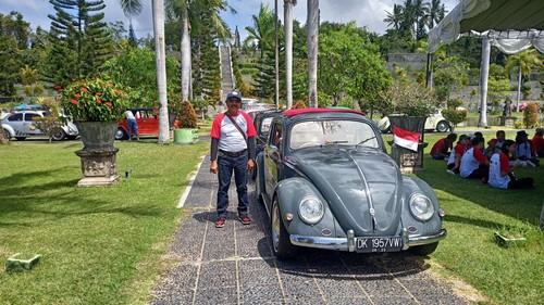 I Wayan Pasek bersama mobil Volkswagen Oval tahun 1957 miliknya.