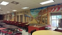 Ini bukanlah food court di mall, melainkan sebuah kantin di sekolah. Dinding kantin dibuat lebih menarik dengan mural suasana pertokoan yang dibuat oleh Joe Wilson. Foto: boredteachers.com