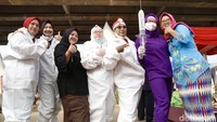 Warga memakai kostum Nakes dengan jarum suntik vaksin booster.