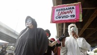 Corona masih ada dan seruan bersama melawannya tergambar dari poster peserta pawai ini.