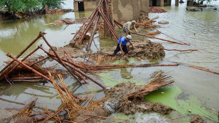 Darurat! 30 Juta Orang Terdampak Banjir di Pakistan Flood victims receive boiled rice from relief workers, after taking refuge on a motorway, following rains and floods during the monsoon season in Charsadda, Pakistan August 27, 2022. REUTERS/Fayaz Aziz