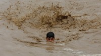 Seorang warga berenang di tengah banjir yang melanda Charsadda, Pakistan, 27 Agustus 2022. REUTERS/Fayaz Aziz.