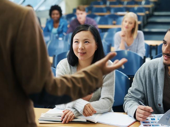 Rearview shot of a teacher talking to his university students