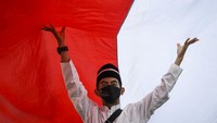 Peserta membentangkan Bendera Merah Putih di kawasan Thamrin, Jakarta, Minggu (28/8/2022).