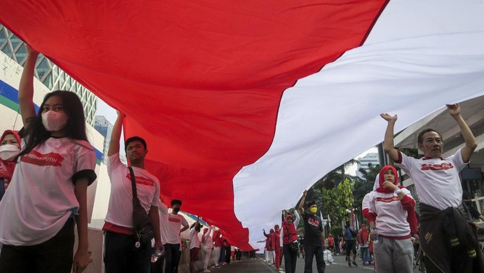 KIRAB MERAH PUTIH Sejumlah peserta membentangkan Bendera Merah Putih di kawasan Monumen Nasional (Monas), Jakarta, Minggu (28/8/2022). Sebanyak 50.000 orang membentangkan bendera merah putih sepanjang 1.700 meter dari kawasan Monas hingga Bundaran Hotel Indonesia dalam rangka memperingati HUT ke-77 Kemerdekaan Republik Indonesia bertemakan 'Pulih Lebih Cepat, Bangkit Lebih Kuat. ANTARA FOTO/M Risyal Hidayat/foc.