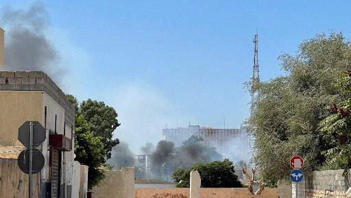 Smoke billows as rival Libyan groups exchange fire in the capital Tripoli, on August 27, 2022. - The fighting broke out in various districts of Tripoli between groups armed with both heavy and light weapons, as two rival governments yet again vie for power in the oil-rich but impoverished North African country. The exchange wounded civilians and raised fears of all-out conflict in a country facing a grave political crisis. (Photo by Mahmud TURKIA / AFP)