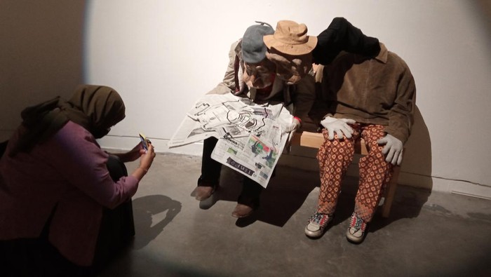 Seorang pengunjung memotret sepasang boneka yang membaca koran dalam Pameran Kelana Boneka di Galeri Salihara, Jakarta, Sabtu (27/8/2022). Pameran Kelana Boneka tersebut akan berlangsung hingga 4 September 2022. ANTARA FOTO/Dodo Karundeng/wsj.