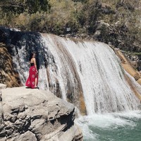 Begini potret Ranty Maria saat berpose di samping air terjun Tanggedu. Sambil mengenakan tanktop hitam dan rok panjang merah berbelahan samping, penampilan Ranty Maria tampak mempesona. Foto: Instagram/@rantymaria