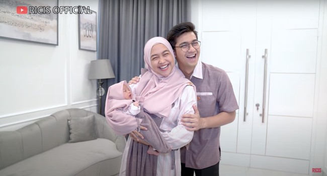 Kompak dengan baby Moana, Ria Ricis dan Teuku Ryan juga tampak mengenakan pakaian senada. Ketiganya terlihat bahagia berfoto bersama. Foto: YouTube/Ricis Official