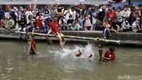 Setelah saling hantam dengan bantal, seorang peserta terjatuh ke sungai.
