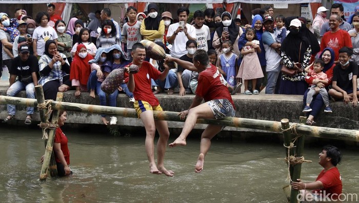 Warga menggelar lomba gebuk batal dan meniti bambu di atas Sungai Kalimalang, Jakarta. Acara ini berlangsung seru.