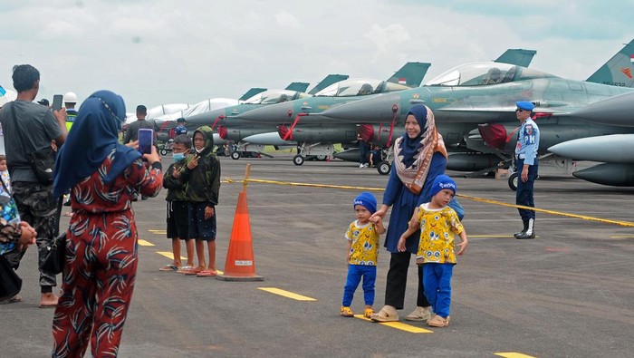 Warga berfoto di depan helikopter TNI pada pameran pesawat tempur di Pangkalan Udara Sri Mulyono Herlambang (Lanud SMH) Palembang, Sumatera Selatan, Minggu (28/8/2022). Lanud SMH Palembang memberikan kesempatan pada warga Kota Palembang untuk melihat lebih dekat pesawat tempur F16 dan helikopter angkatan udara melalui pameran ini. ANTARA FOTO/Feny Selly/foc.