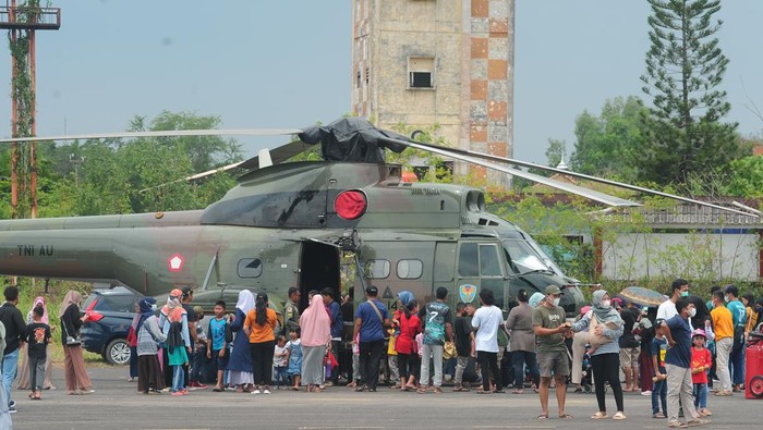 Warga berfoto di depan helikopter TNI pada pameran pesawat tempur di Pangkalan Udara Sri Mulyono Herlambang (Lanud SMH) Palembang, Sumatera Selatan, Minggu (28/8/2022). Lanud SMH Palembang memberikan kesempatan pada warga Kota Palembang untuk melihat lebih dekat pesawat tempur F16 dan helikopter angkatan udara melalui pameran ini. ANTARA FOTO/Feny Selly/foc.