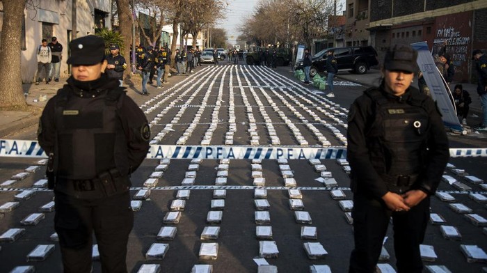 Police stand guard over seized packages of cocaine displayed to the press in Rosario, Santa Fe province, Argentina on August 26, 2022. - Federal Police officers seized more than 1,600 kilos of cocaine, valued at some US$60 million, which were about to leave through the waterway to Dubai, authorities said. (Photo by AFP) (Photo by STR/AFP via Getty Images)