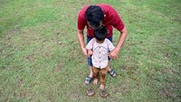 Orang tua menemani anaknya belajar bermain permainan tradisional. Festival desa wisata tersebut merupakan serangkaian kegiatan yang diselenggarakan dengan tujuan mempromosikan desa-desa wisata yang ada di Aceh.  