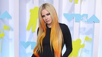 Lavigne mengenakan t-shirt hitam lengan panjang yang dimasukkan ke dalam celana lebar. Foto: Getty Images/Dia Dipasupil