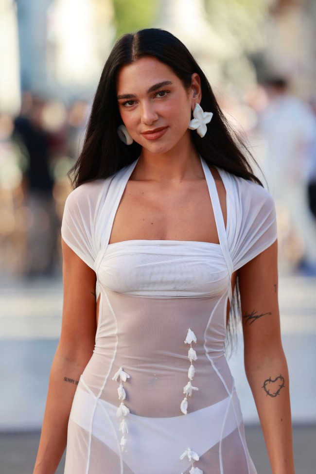 Dua Lipa menyempurnakan penampilannya yang serba putih dengan anting-anting ukuran besar yang berbeda bentuk. Pada telinga kanan dia memakai anting bintang, telinga kiri anting lingkaran ukuran besar. Foto: Dok. Arnold Jerocki/Getty Images